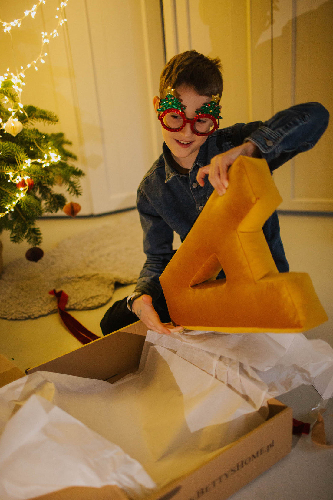 boy opening xmas gift with velvet letter cushion by bettys  home