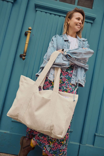Young woman with corduroy shopping bag in cream colour
