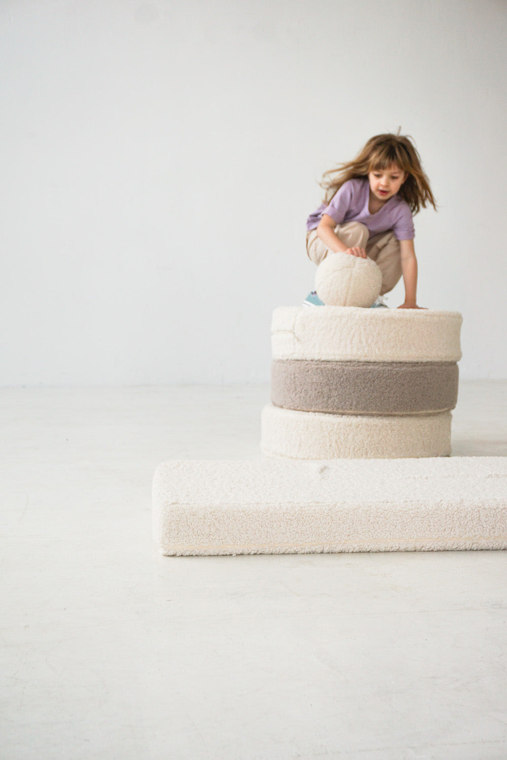 girl playing on boucle mattress and boucle pouf by bettys home with boucle ball
