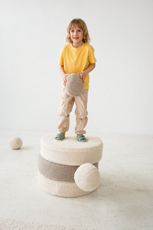 little boy standing on boucle large pouf by bettys home with boucle ball cushion 