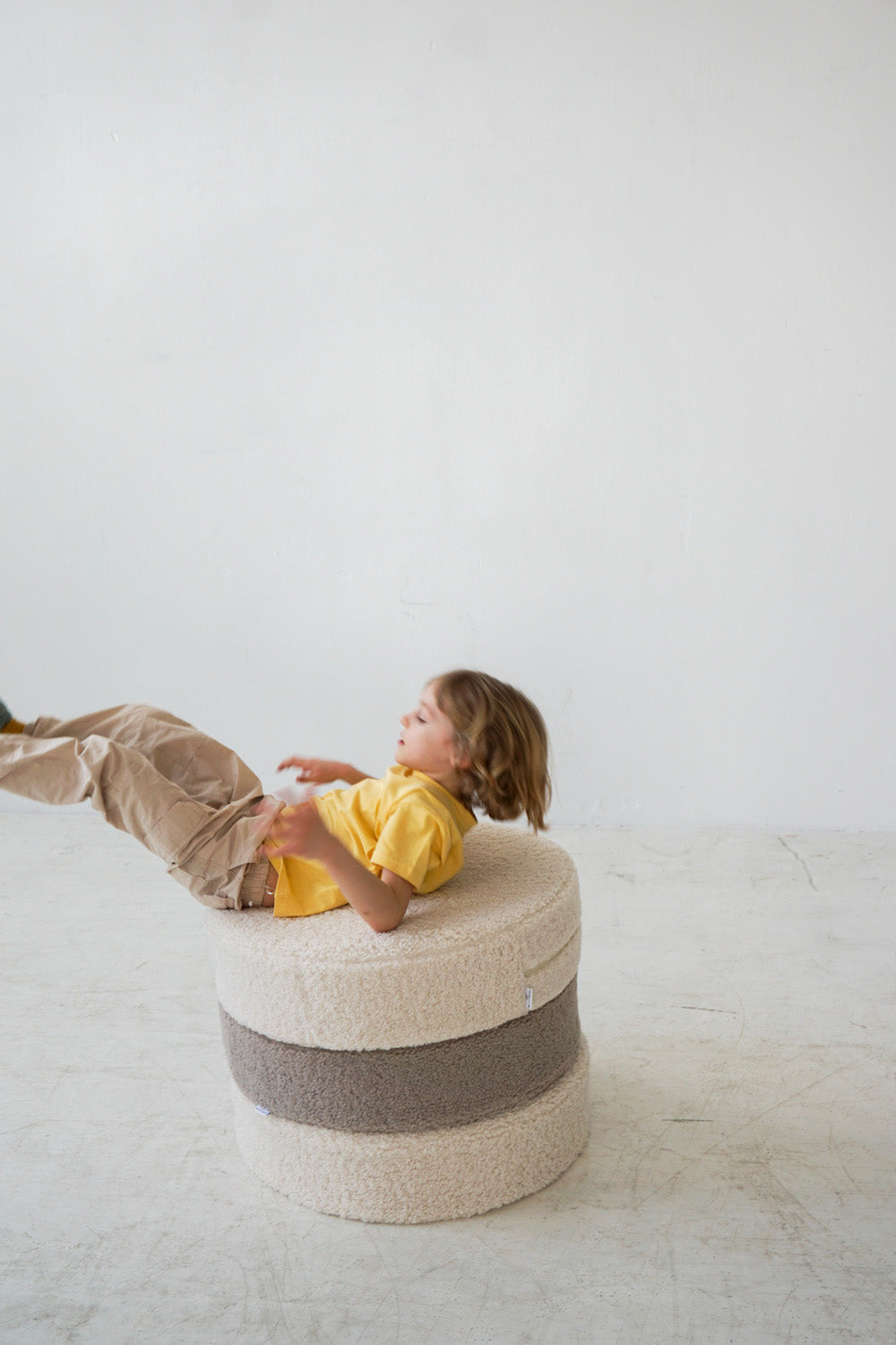 boy lying on large boucle pouf by bettys home 2