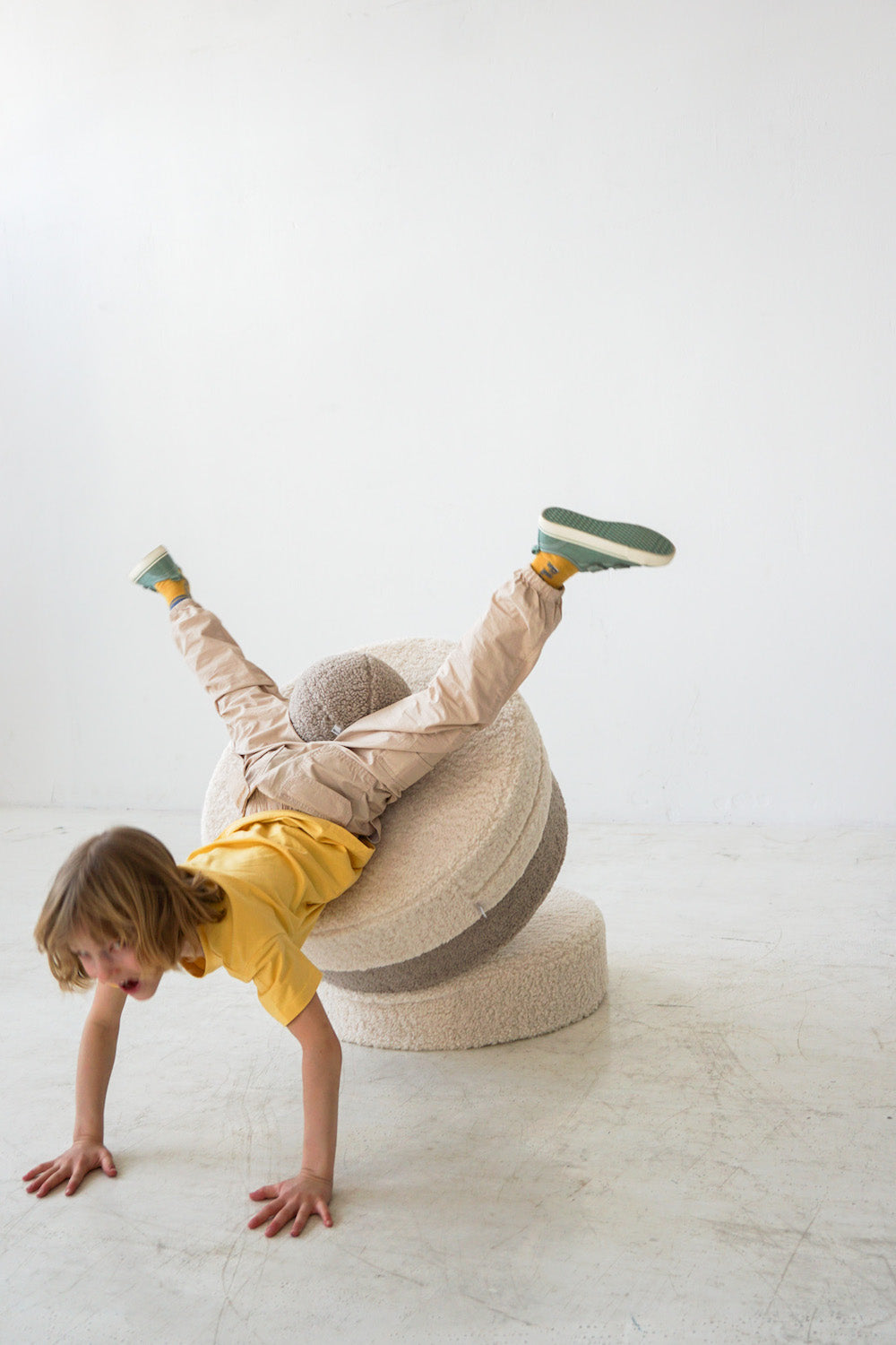 little boy playing on boucle pouf with boucle ball by bettys home in his legs 4