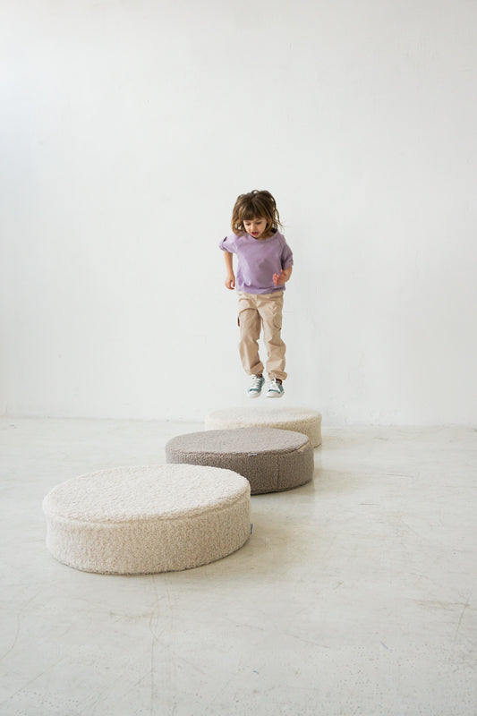 little girl jumping on floor boucle floor pouf by bettys home 
