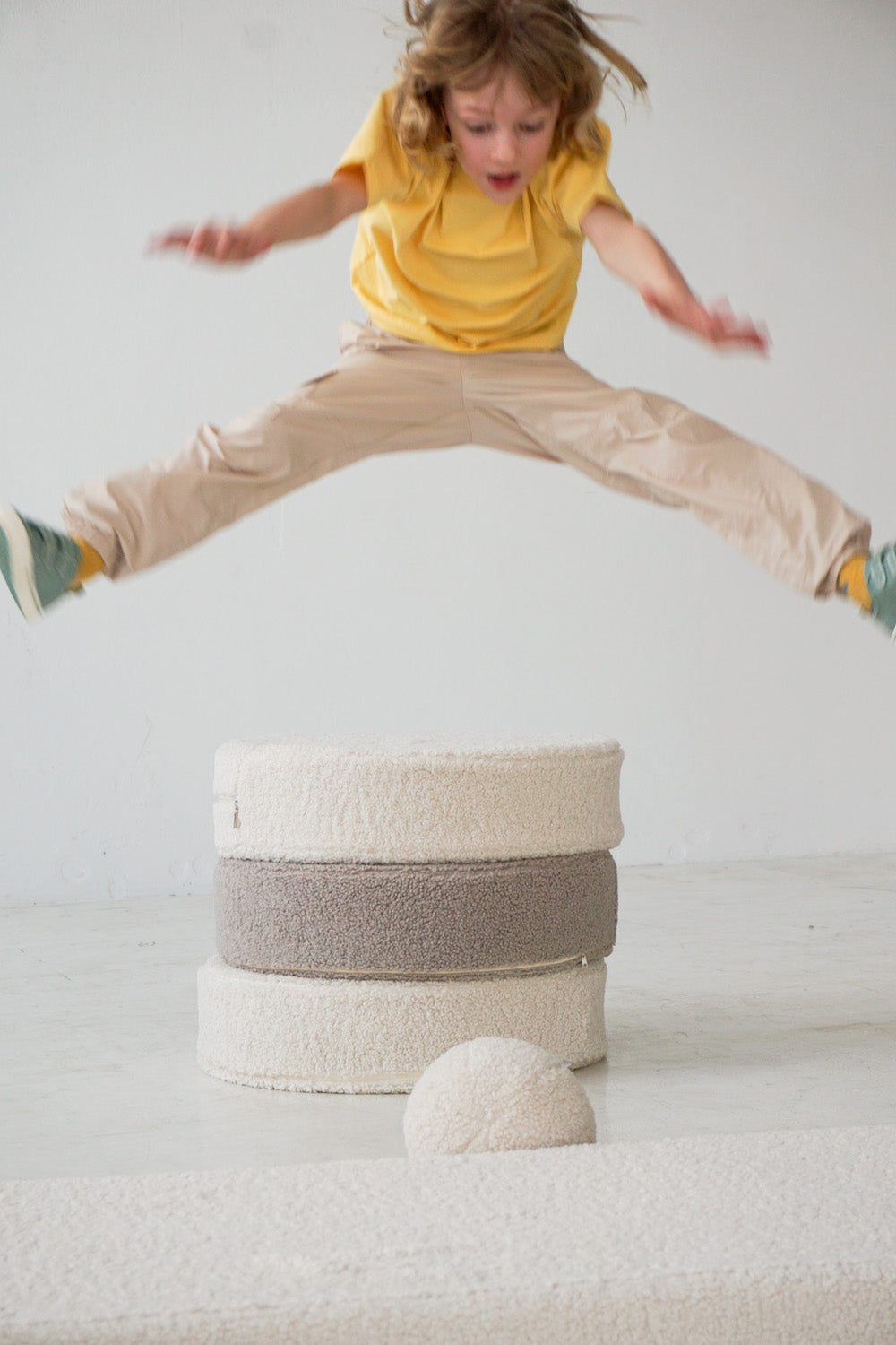 little boy jumping from boucle pouf by bettys home w