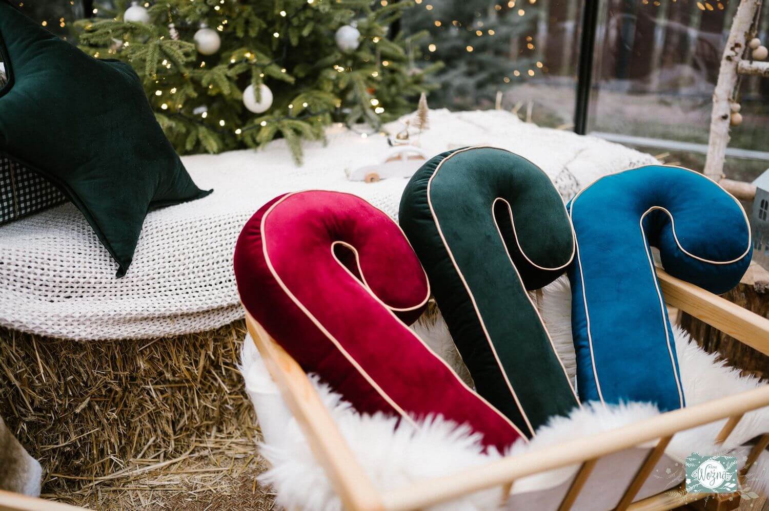 christmas candy cane cushions in three colours near to Christmas tree as christmas decorations