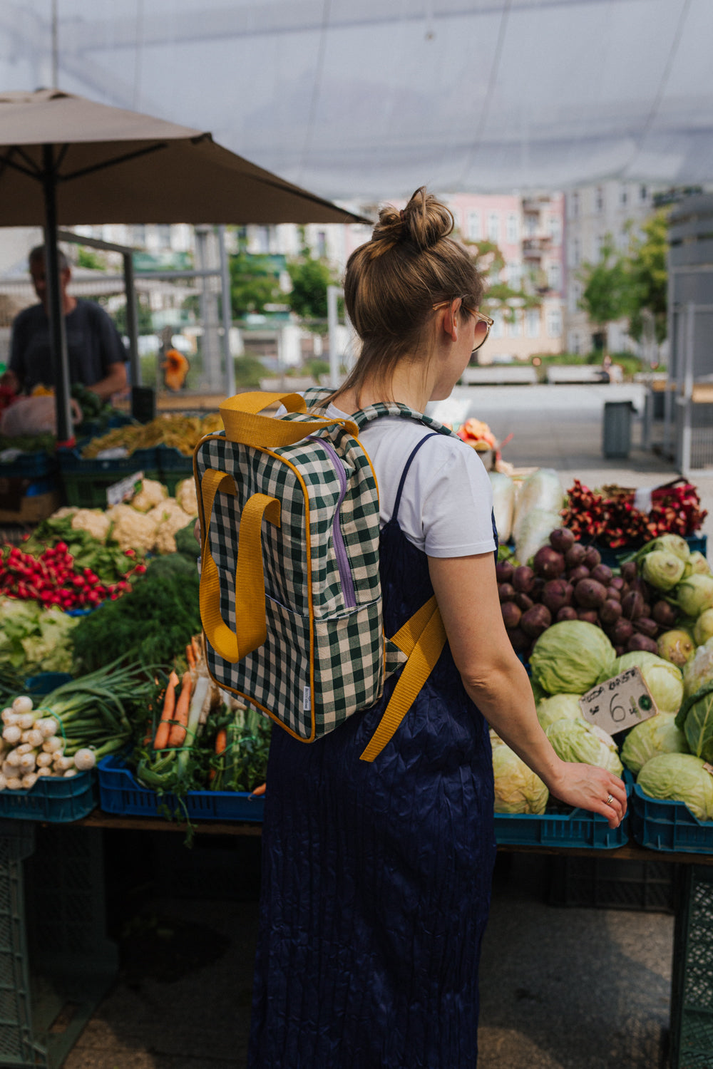 Young woman in the city shopping with green gingham backpack. checkered backpack in stylish urban design by bettys home