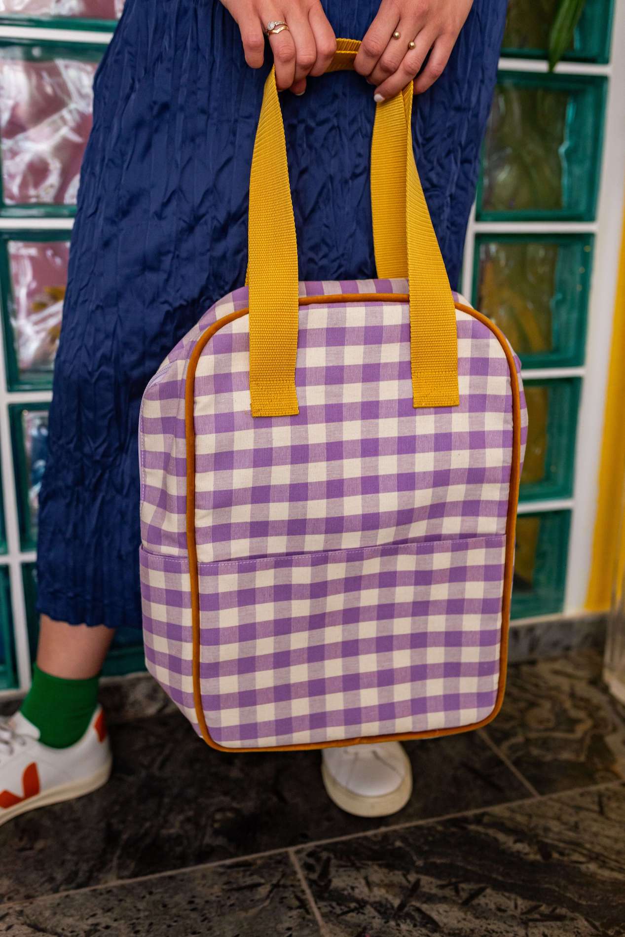 lilac gingham backpack by bettys home held by woman in jeans skirt