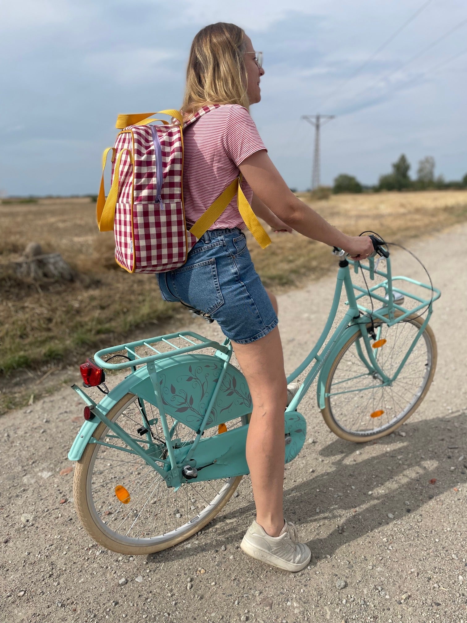 girl on mint bike with red checkered backpack by bettys home on trip. gingham retro backpack in red