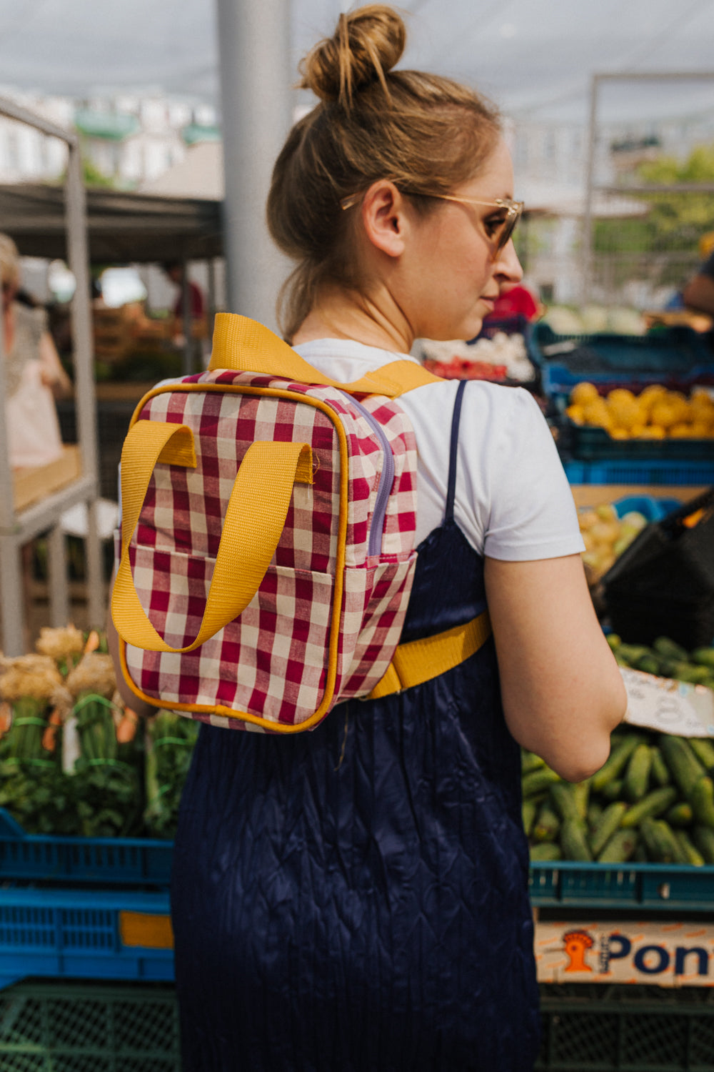 young woman with small gingham backpack while shopping. checkered small backpack 