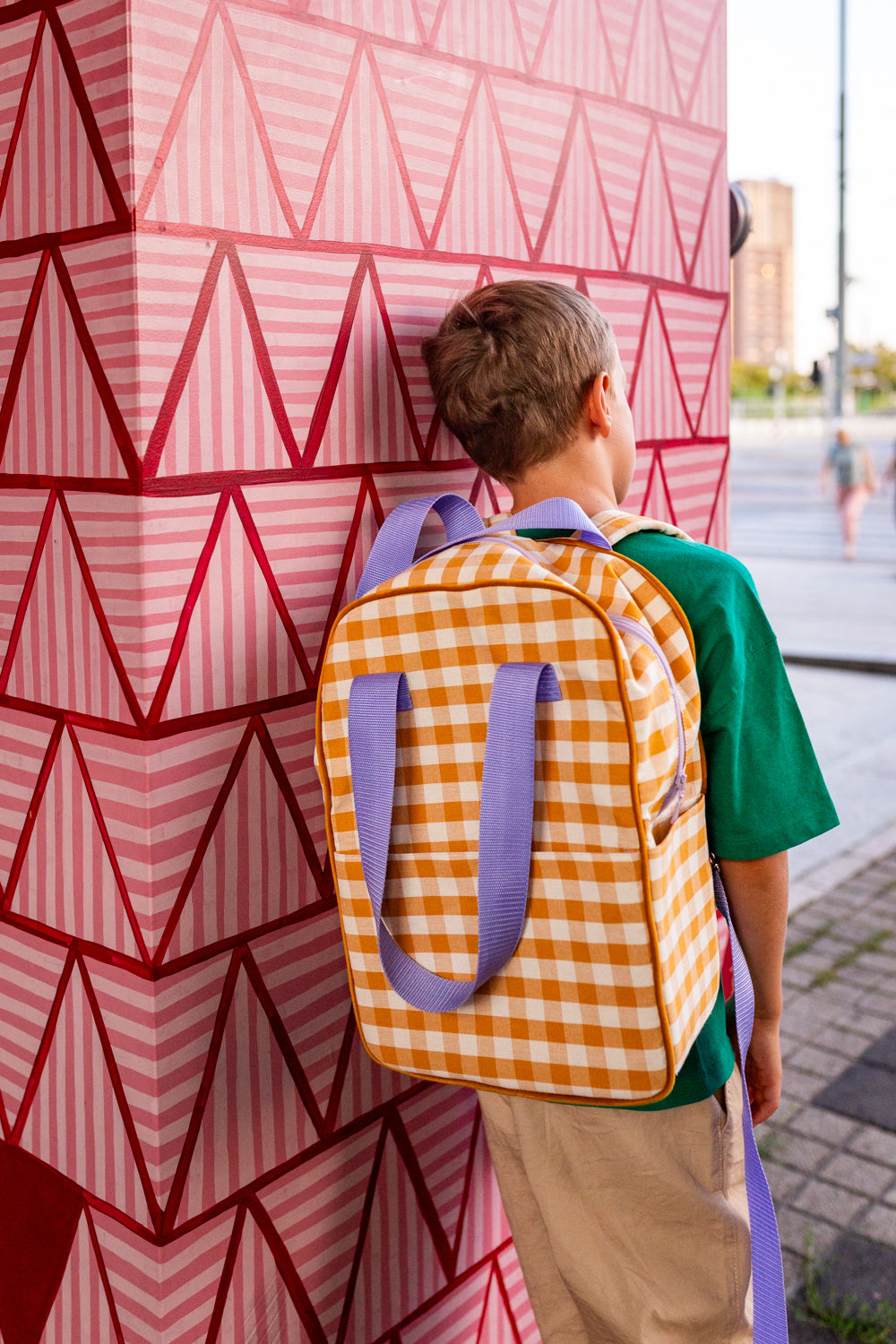 young boy standing outside school with yellow gingham backpack by betty's home. yellow checkered backpack 