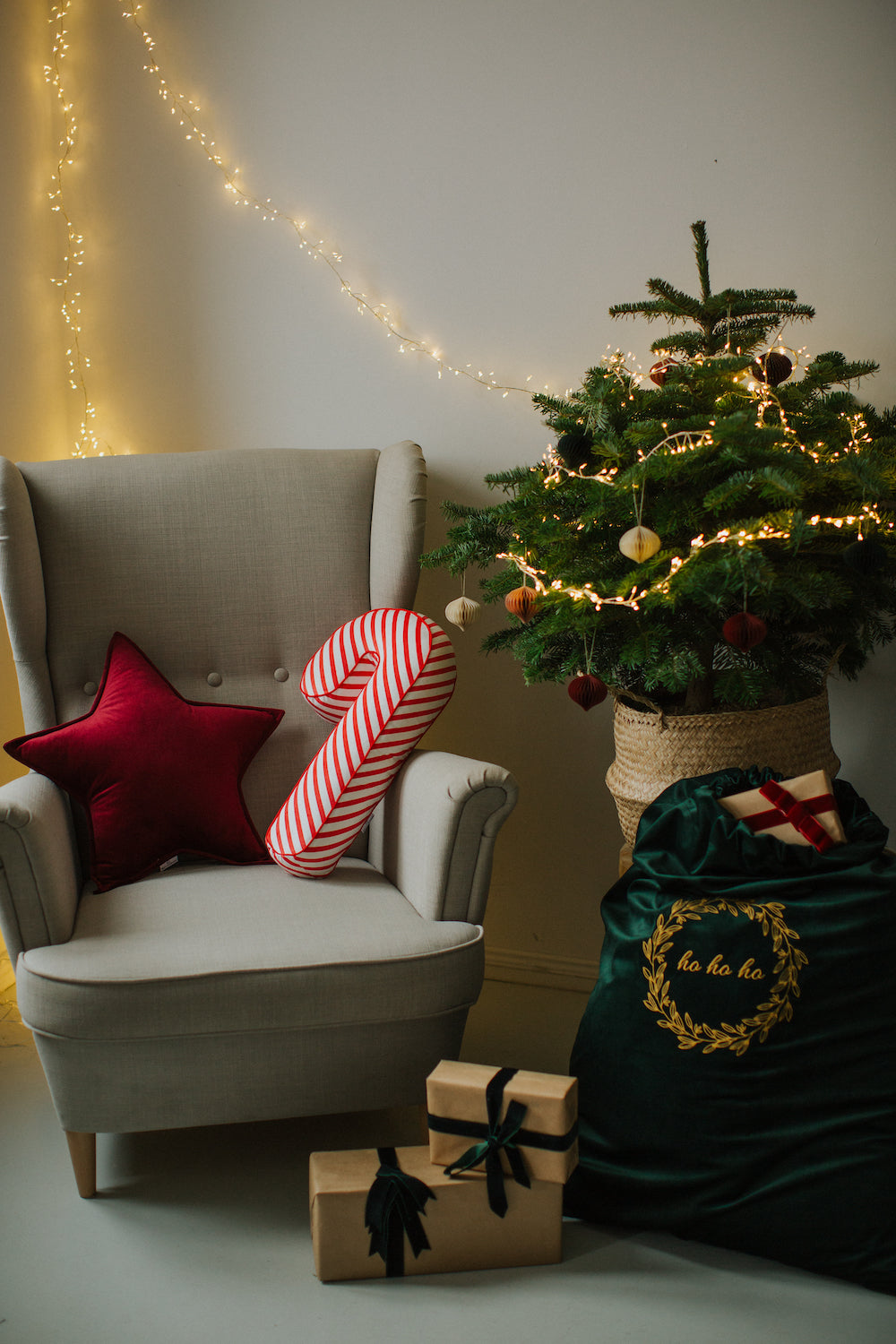 christmas sack for gifts standing next to christmas tree and armchair with candy cane cushion