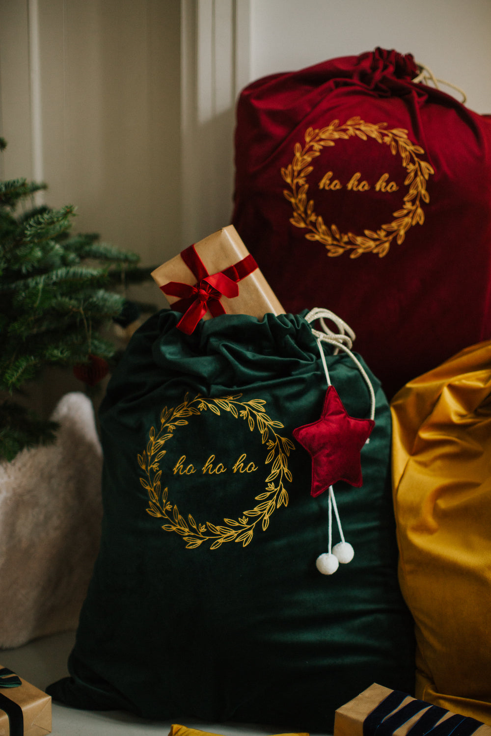 Christmas Sack in Green with red star pendant by Bettys Home standing next to christmas tree 