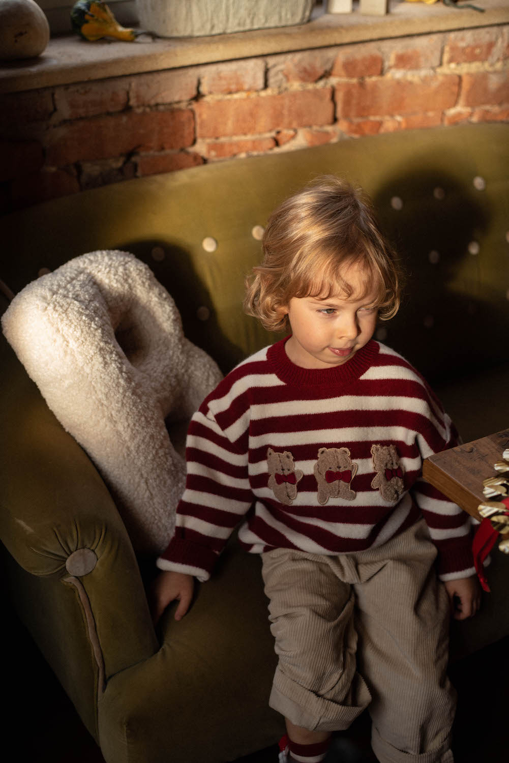 little boy sitting on sofa next to boucle letter cushion B birthday gift idea