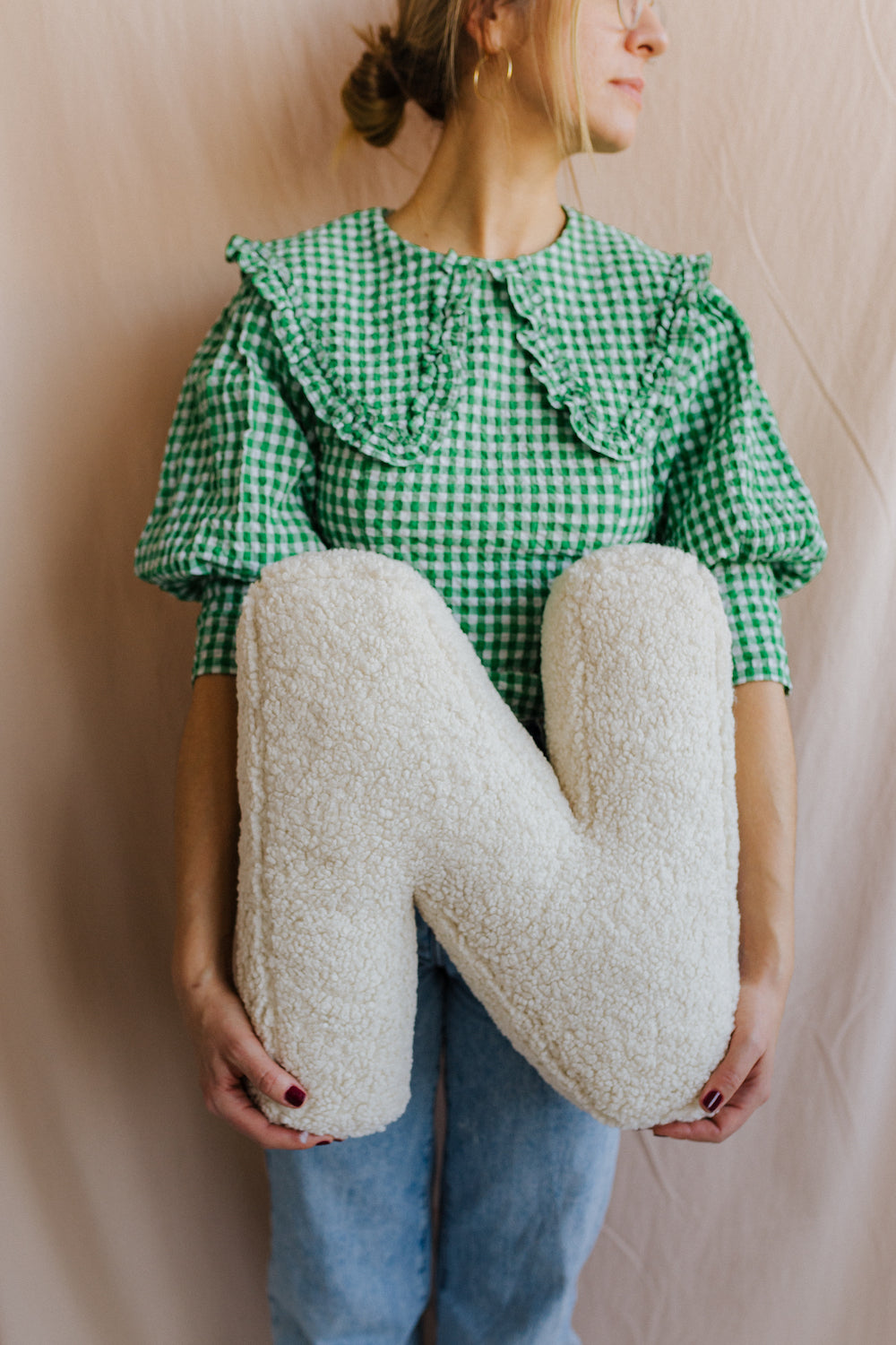 Boucle Letter cushion N by Bettys Home Teddy Letter Pillow held by young woman in green checkered shirt 