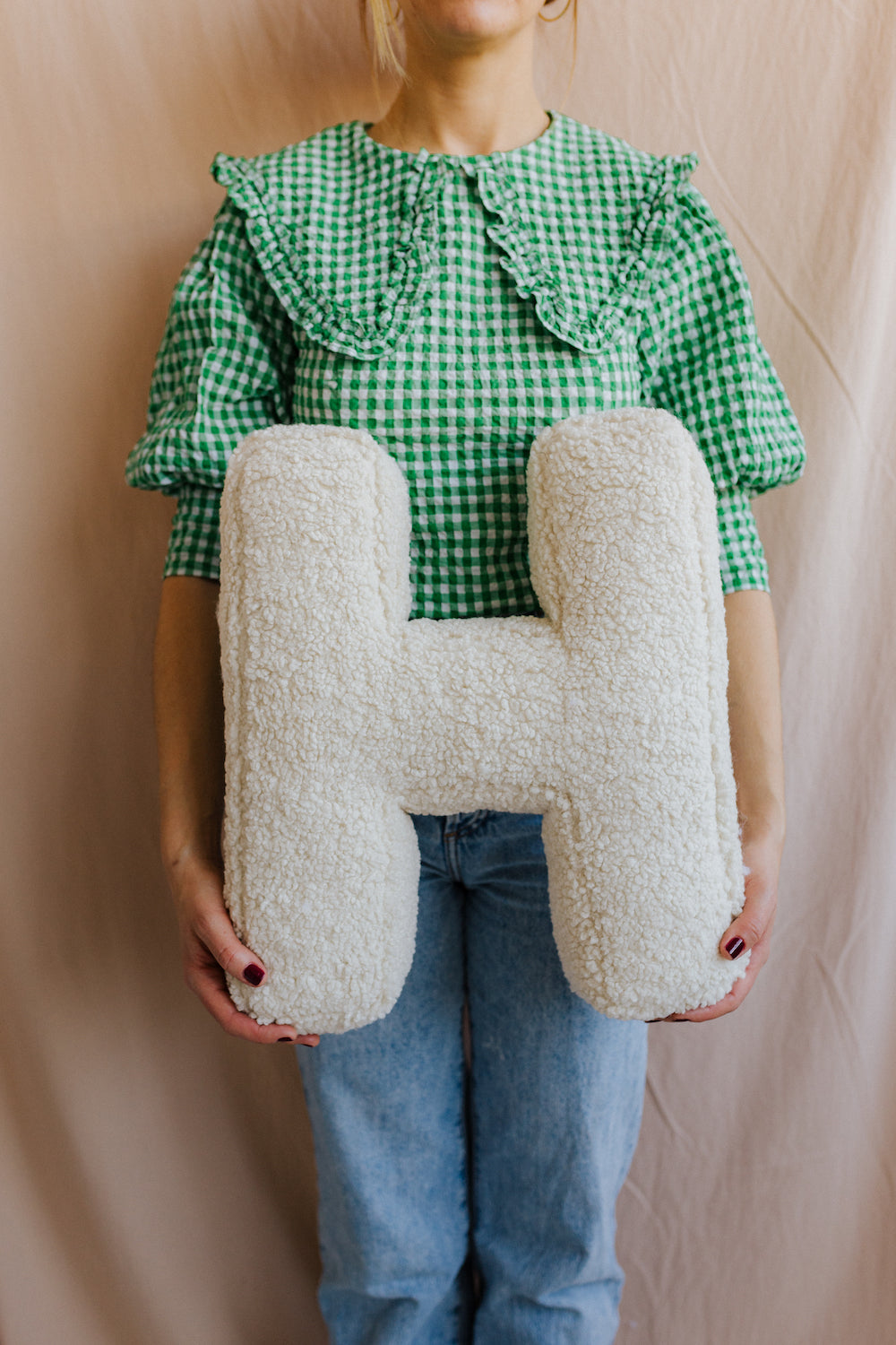 Boucle letter cushion H Teddy pillow by bettys home held by woman in green shirt in her hands