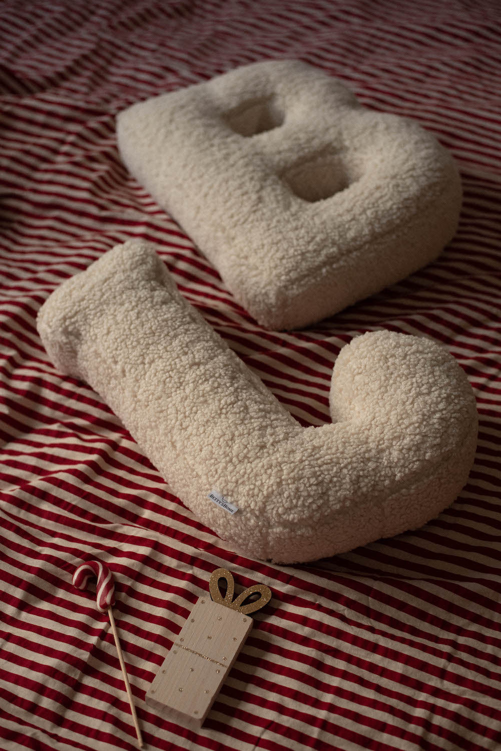 Boucle Letter cushion B and J by Bettys Home Teddy Letter Pillow lying in bedroom on bed as n=bedroom deco idea