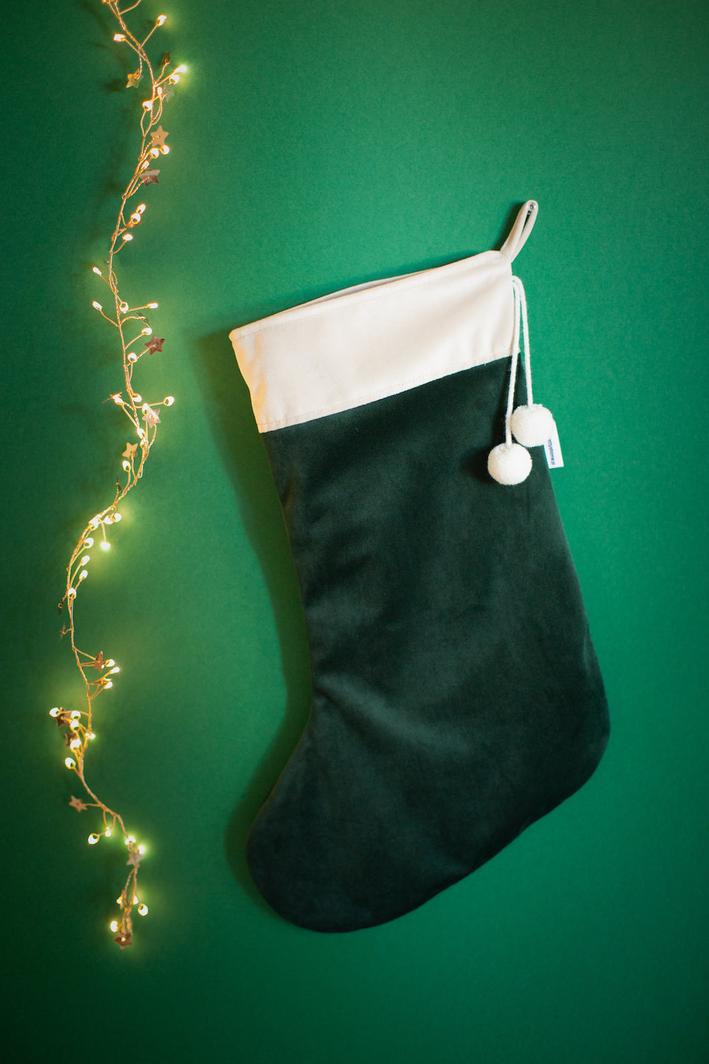 christmas stocking green by Bettys Home hanging on green wall as traditional Christmas decoration