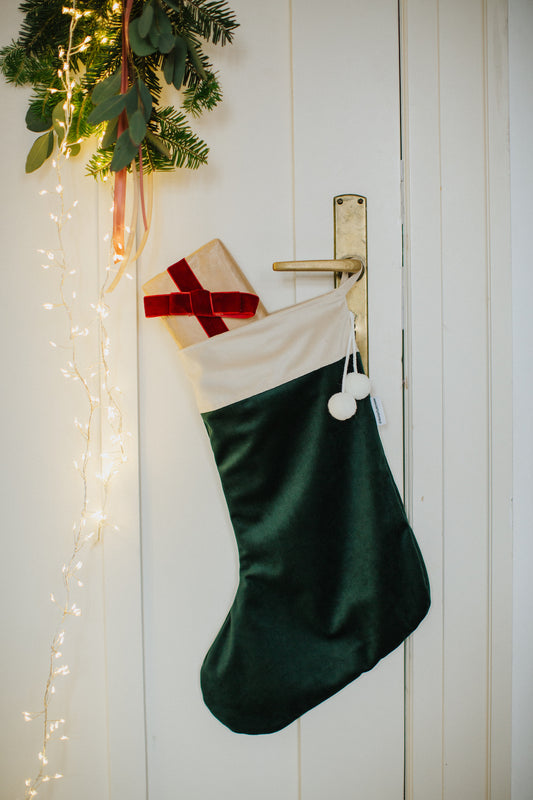 christmas stocking green by Bettys Home hanging on a door handle with small gift inside. christmas fireplace decor
