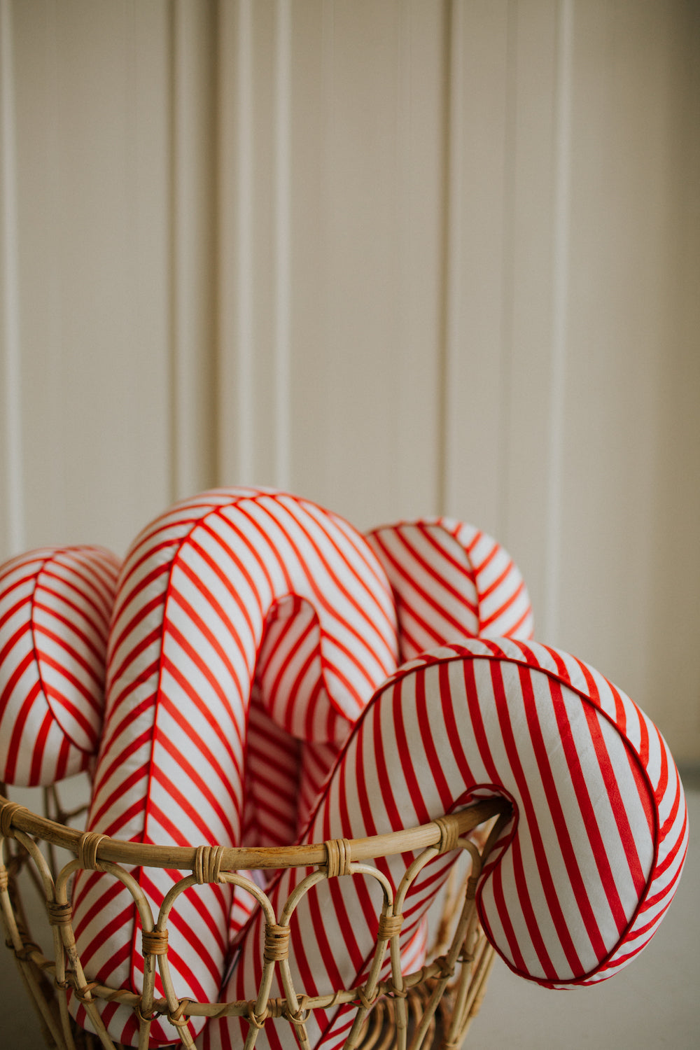 Christmas candy cane cushion red stripes by bettys home some of them sticking out of a wicker basket 