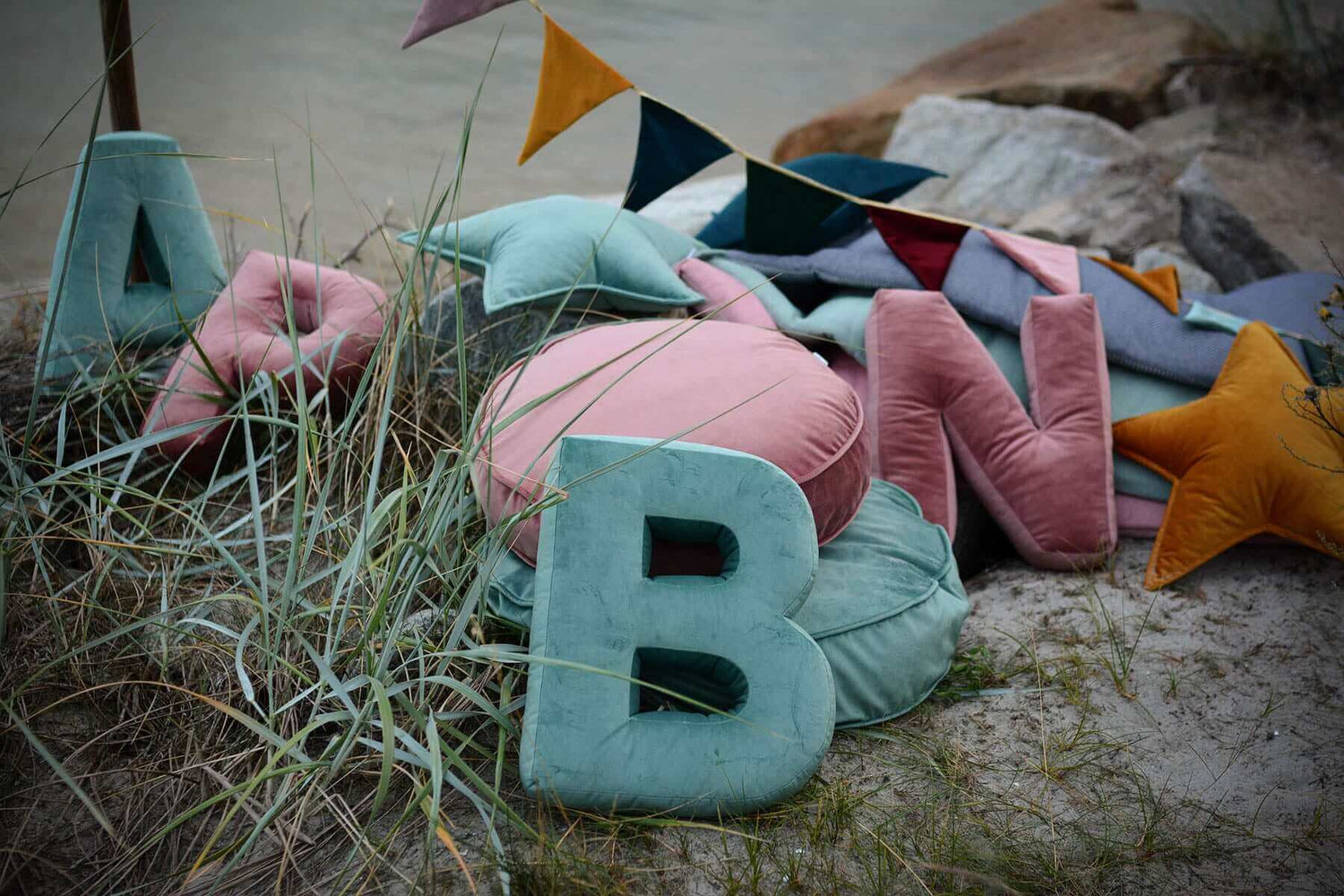 velvet letter cushion b in mint on sand and velvet triangle garland by bettys home