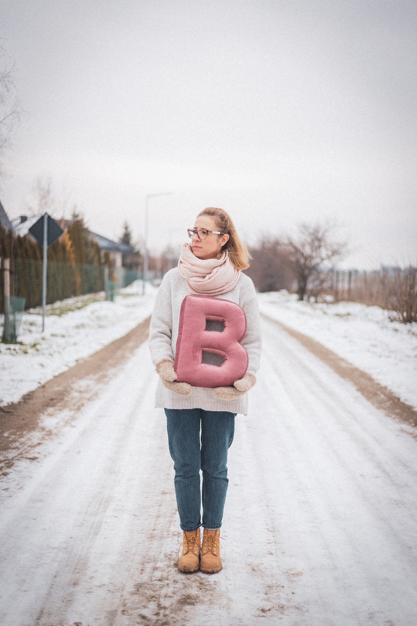 Girl standing in winter with velvet letter cushion B pink. Holiday present for boyfriend. Gift ideas personalised