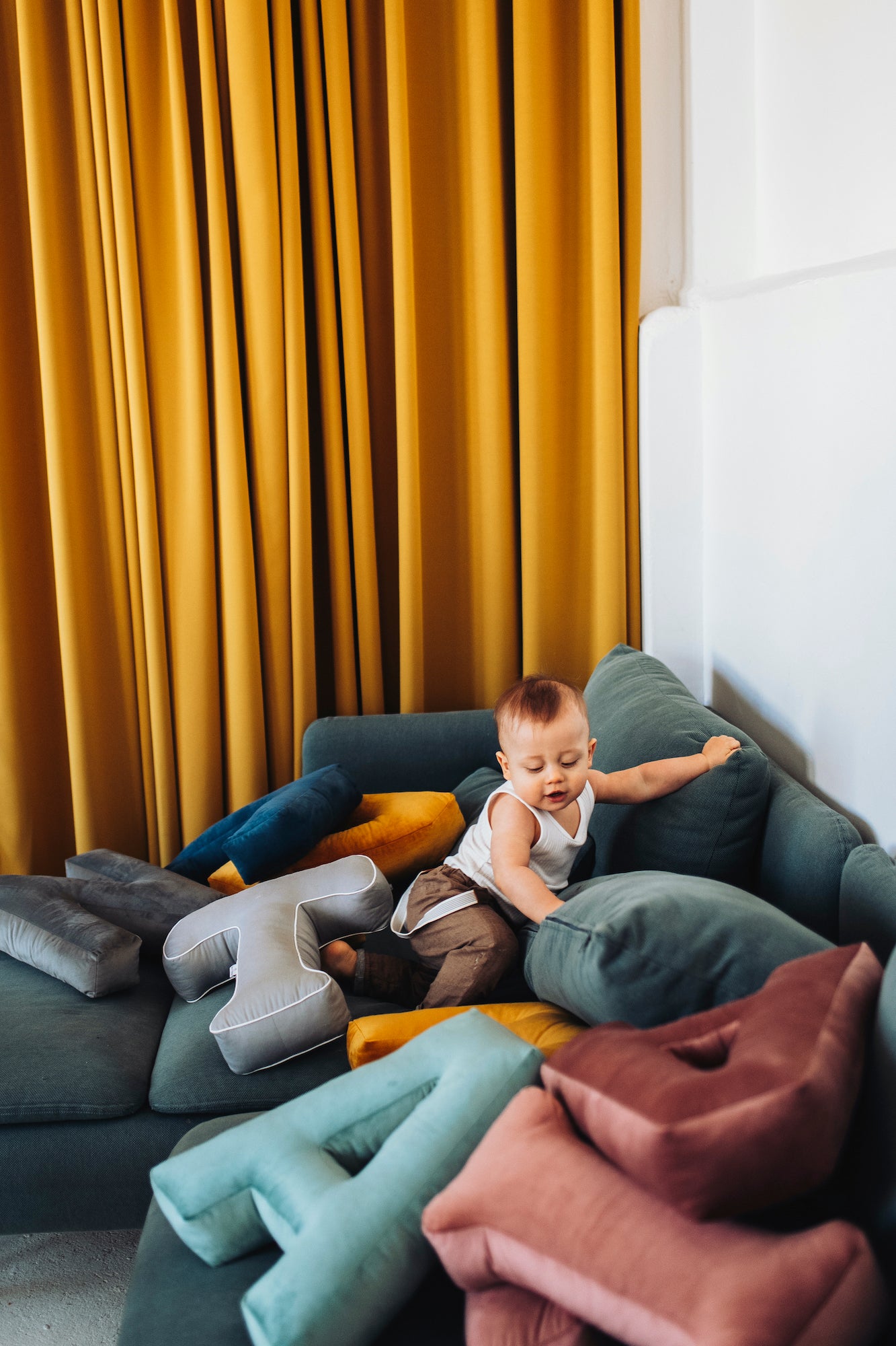 small kid on couch with Velvet letter cushions by Bettys Home 