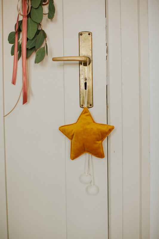 velvet little star pendant yellow with pompoms by bettys home hanging on door handle 