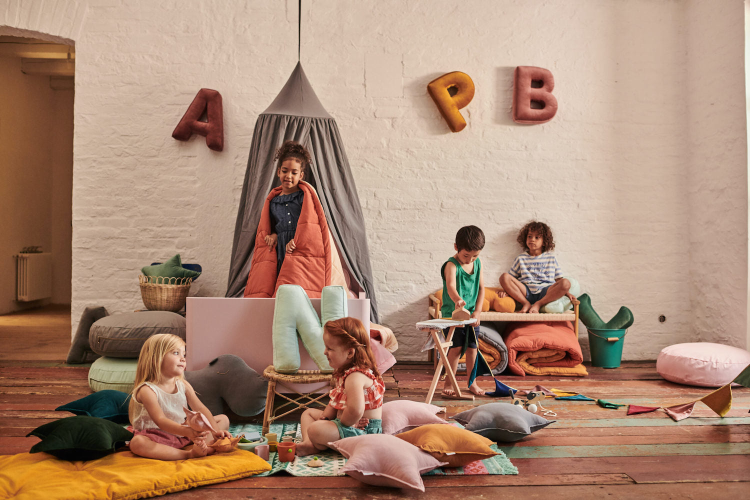 kids in kindergarten with velvet letter cushions by bettys home and velvet star cushion on floor 