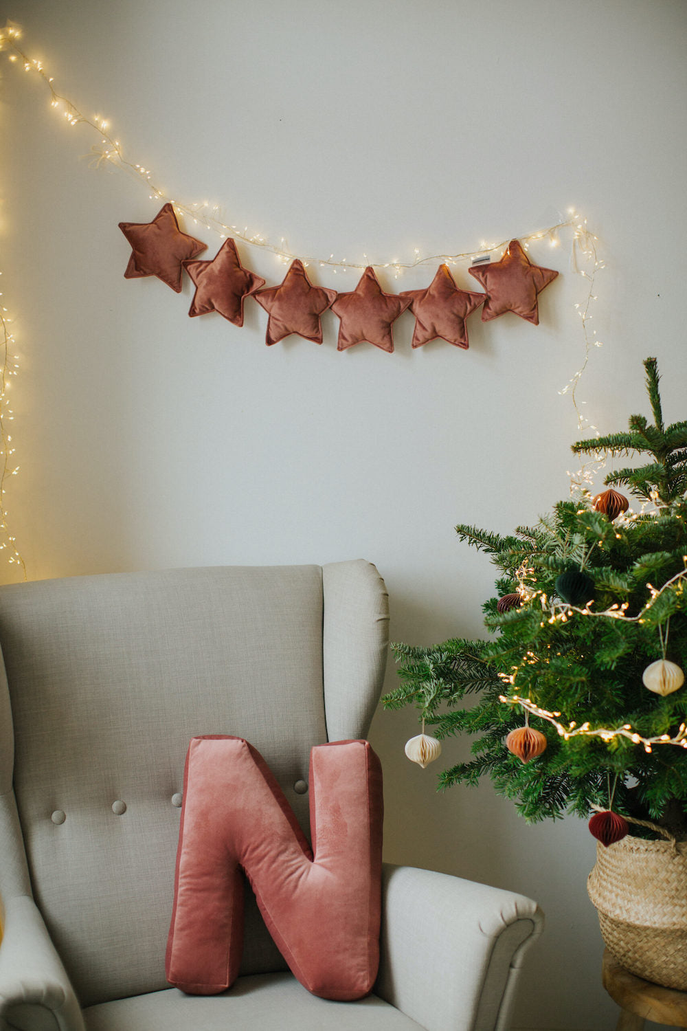 velvet star garland in pink old rose by bettys home over armchair with velvet letter cushion N pink next to christmas tree