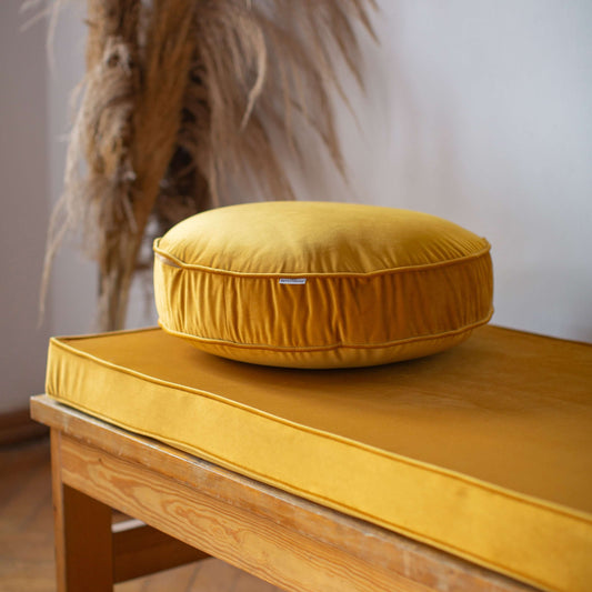 Small Velvet Pouf Yellow on velvet mattress on bench 